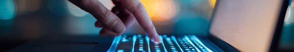 person's hand operating a laptop