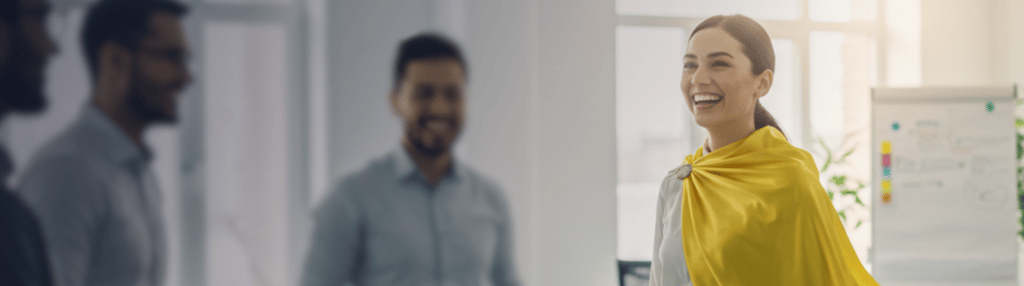 Businesswoman wearing a yellow cape in an office meeting.